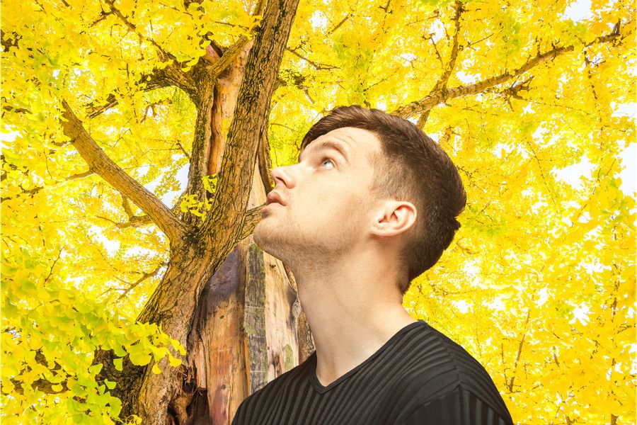 The young man looking up on yellow studio background