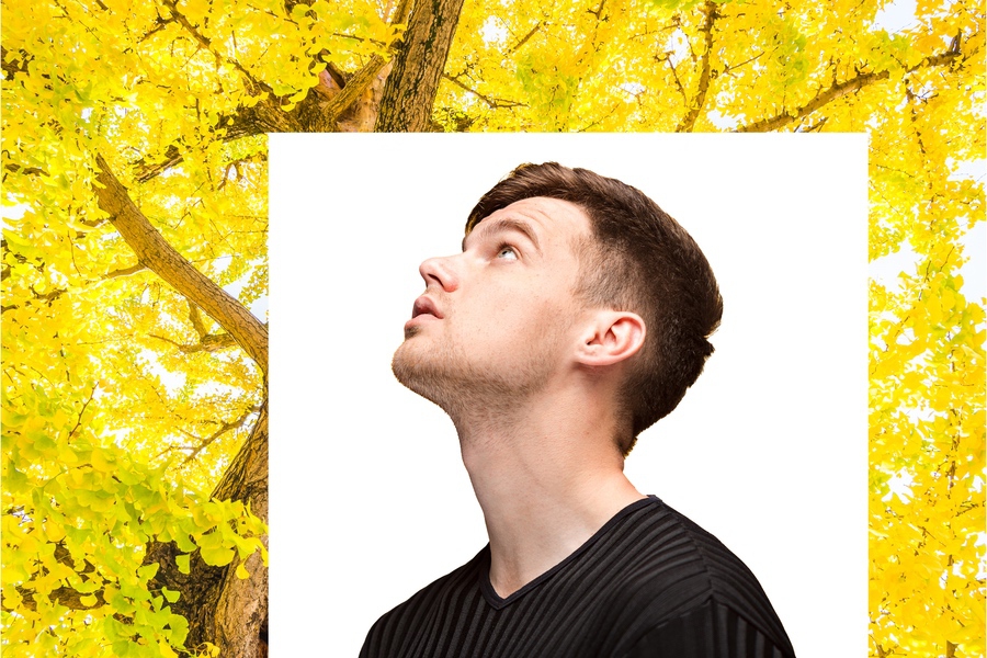 The young man looking up on yellow studio background